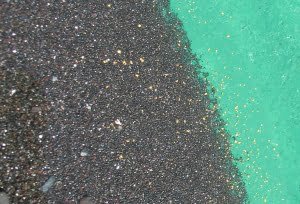 Black sands in gold pan, commonly associated with gold deposits
